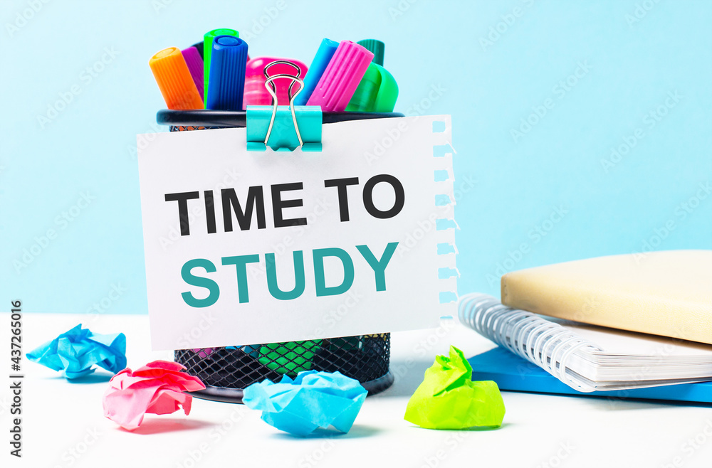 Poster on a blue background - a stand with bright markers, notepads and multi-colored crumpled pieces of pa