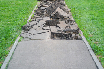 A path with broken asphalt ahead. The concept of obstacles on the way, or in travel, or in life.