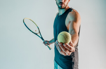 Sportsman hold and showing tennis ball in hand