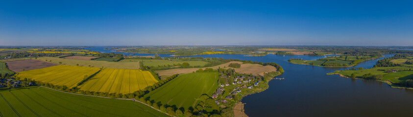 Panorama aerial view of of the Schlei, an inlet of the Baltic Sea with rapeseed fields, near the village Missunde.