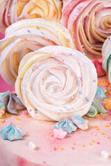 Birthday pink and white cake decorated with colorful meringue