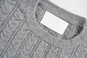Closeup of an inner label on the neck of a pretty gray wool sweater. Blank space to place a logo,...