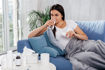 Calm woman taking prescribed medicine at home