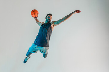 Sportsman jumping and want throw basketball ball