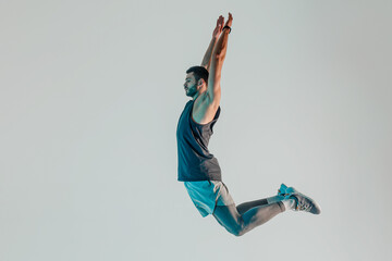Young bearded european sportsman jumping in studio