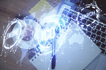 Blockchain theme hologram drawings over computer on the desktop background. Top view. Multi exposure. Concept of cryptoeconomy.