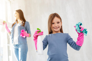 Positive child helping her mother with cleaning