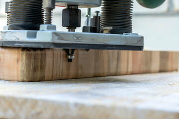 Machining with an electric wood plank router, hand-held router close-up. Selective focus.