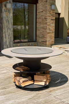 Kettle Grill Pit with Cast Iron Grid with flames . Round table-cooking surface. Hot BBQ on Backyard