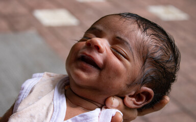 a new borne boy child sleeping on his mother's hand with smile
