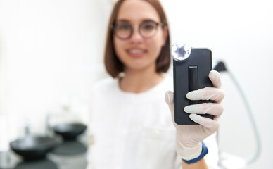 Focus on a dermatoscope to analyze and examine moles and skin growths and neoplasms in the doctor's...