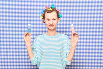 Woman with skincare product on face, with bright hair curlers on head