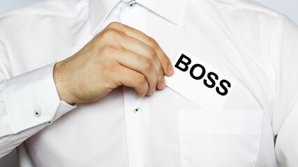 A businessman in a white shirt shows a business card with text BOSS, copy space, business concept