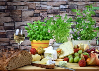 cheese board with camenbert, blue cheese, cheese with herbs and pepper and more
