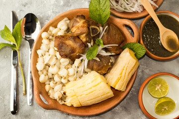 Chicharrón de chancho con mote y yuca, comida peruana vista cenital en fondo gris 