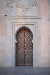 elegant ornamental forged metal  entrance to a beautiful Islamic mosque on the ocean at sunset