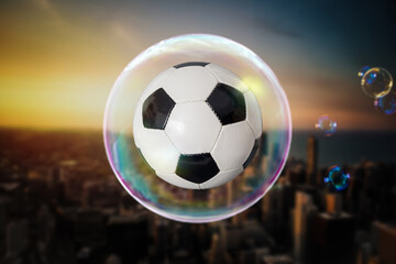 Fußball in einer Seifenblase über einer Stadt am Abend