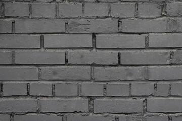 A gray brick wall. Background with a brickwork texture. The walls of street houses. Loft style.