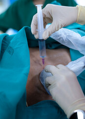 Anesthetist press ultrasound probe and injection more medication on the patient’s back for...