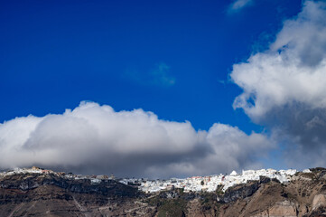View of clouds above Imerovigly from sea. Santorini island, Greece.