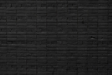 A black brick wall. Background with a brickwork texture. The walls of street houses. Loft style.