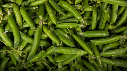 Ripe strings of green peas in a box