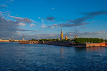 Fototapeta premium View of the Peter and Paul Fortress and Vasilievsky Island from the Trinity Bridge over the Neva River on a sunny summer morning with clouds, St. Petersburg, Russia