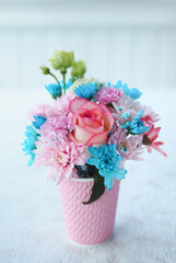 Beautiful bouquet of flowers in a pink glass on the table..