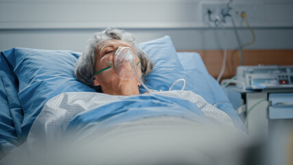 Hospital Ward: Portrait of Beautiful Elderly Woman Wearing Oxygen Mask Sleeping in Bed, Fully...