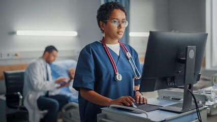 Hospital Ward: Professional Smiling Black Female Head Nurse or Doctor Wearing Stethoscope Uses...