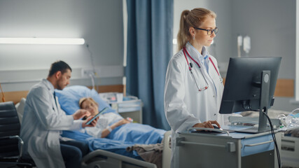 Obraz premium Hospital Ward: Professional Female Doctor or Surgeon Uses Medical Computer. In the Background Modern Equipment Clinic Doctor Sitting and Caring for Patient Recovering After Successful Surgery in Bed