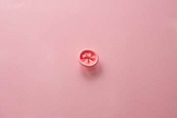 Metaphor image of the anus on a pink background. Rectal health, anus hygiene. - obrazy, fototapety, plakaty