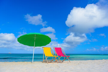 Beach chairs with umbrella on the shoreline, beautiful beach