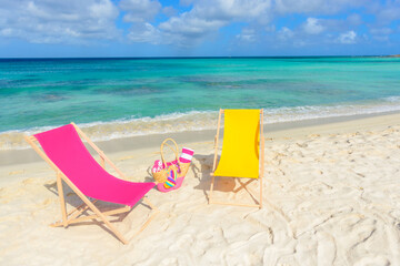 Beach chairs, beach bag, flip flops, beach towel on the shoreline, beautiful beach