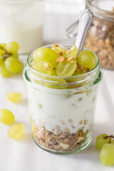 Fruit dessert. Yogurt, muesli and grapes in glass jar