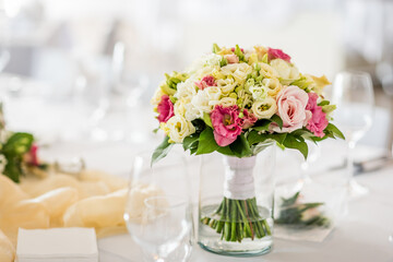 Detail of flowers on a wedding table which is ready for the guests and bride with the groom.