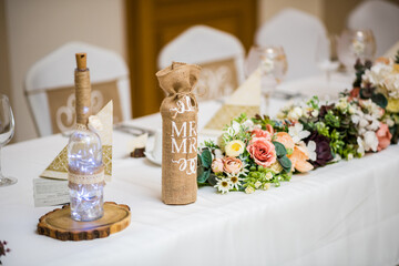 Detail of flowers on a wedding table which is ready for the guests and bride with the groom.