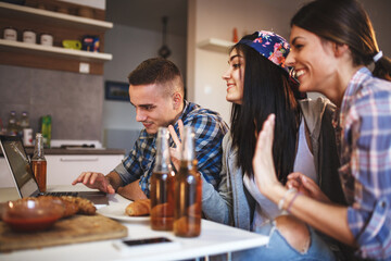 Group of young students at the home party.Thay watching online stream and making fun.	
