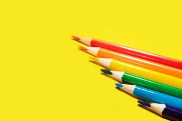 crayons concept closeup of various colors, rainbow color selection, equality or LGBT gay pride flag or beautiful life concept on yellow background