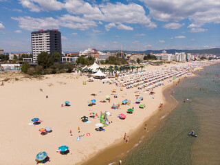 Summer background. Sun umbrellas, sunbeds on sand beach, drone aerial view from above. Sunny Beach in Bulgaria. Summer holidays in Europe during quarantine.