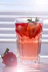 Still life with glass of cooling strawberry Sangria with sparkling wine, strawberry, ice cubes. Refreshing summer alcoholic cocktail drink , lemonade or ice tea. Copy space for text