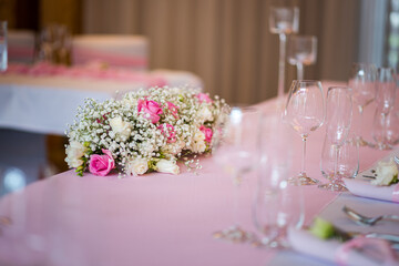 Detail of flowers on a wedding table which is ready for the guests and bride with the groom.