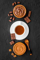 Cocoa beans and powder with hot chocolate in white cup. Top view, flat lay