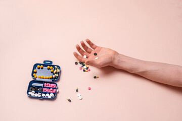 human outstretched hand laying with dose of pharmacy and medicine pills, overdose concept