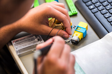 Technician working, soldering on electrical equipment, logic board, pcb. A student of electrical...