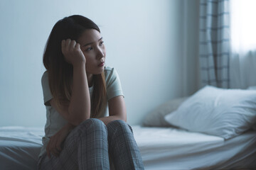 Depressed woman sitting on the bed had bad emotional feel lonely at home. concept of sadness and relationship breakdown