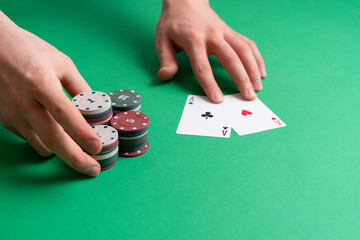hands take the casino poker chips on the green table, gambling and luck concept