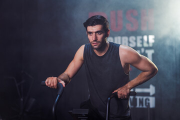 Caucasian male gym trainer exercising on spinning exercise bike in fitness gym. Health care and fitness in gym concept