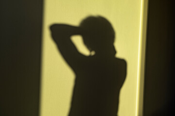 Woman shadow on yellow wall as mental health, lonely person concept, no focus, smooth shut