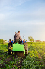 Obraz premium Farmer digs out of potatoes on a farm field. Harvest first potatoes in early spring. Farming and farmland. Agro industry and agribusiness. Harvesting mechanization in developing countries.